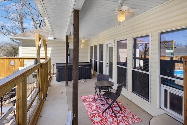 view of patio with ceiling fan and a hot tub