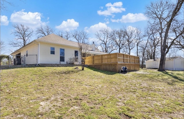 back of property featuring fence, a lawn, a chimney, and a gate