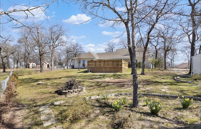 view of yard with a fire pit, a deck, and fence