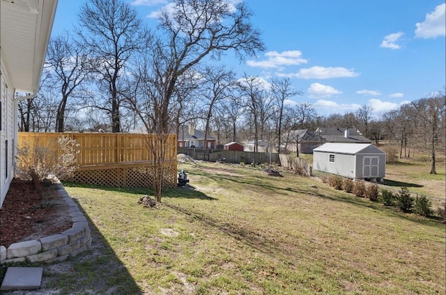 view of yard with an outbuilding, a storage shed, and a fenced backyard