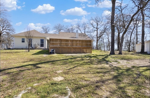 back of house with a lawn and a sunroom