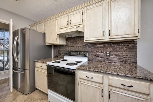 kitchen featuring under cabinet range hood, tasteful backsplash, freestanding refrigerator, and electric stove