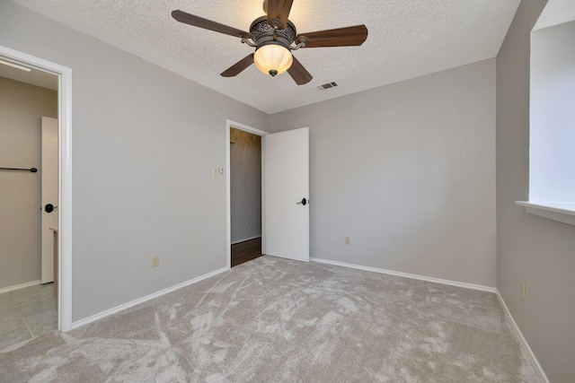 unfurnished bedroom featuring visible vents, baseboards, a textured ceiling, and carpet floors