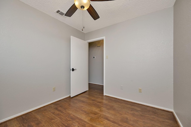 unfurnished room featuring visible vents, a ceiling fan, a textured ceiling, wood finished floors, and baseboards