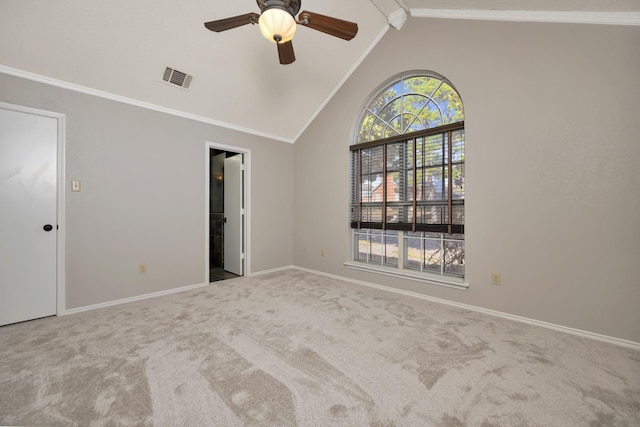 carpeted empty room featuring visible vents, crown molding, baseboards, and vaulted ceiling