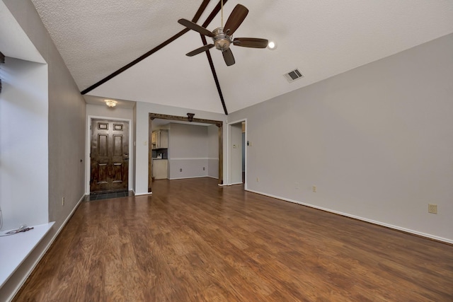 unfurnished living room with visible vents, dark wood-type flooring, a textured ceiling, ceiling fan, and vaulted ceiling