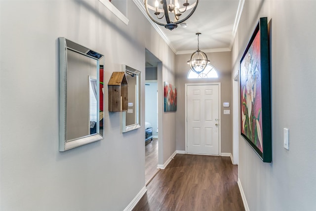 doorway to outside with baseboards, dark wood-style flooring, a chandelier, and crown molding