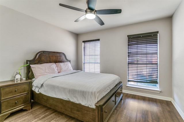 bedroom with a ceiling fan, dark wood-type flooring, and baseboards