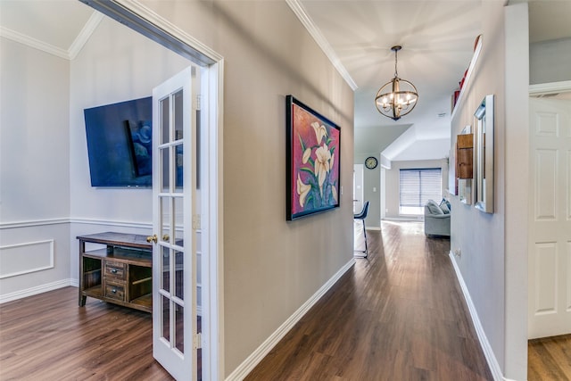 hall featuring wainscoting, an inviting chandelier, wood finished floors, and crown molding