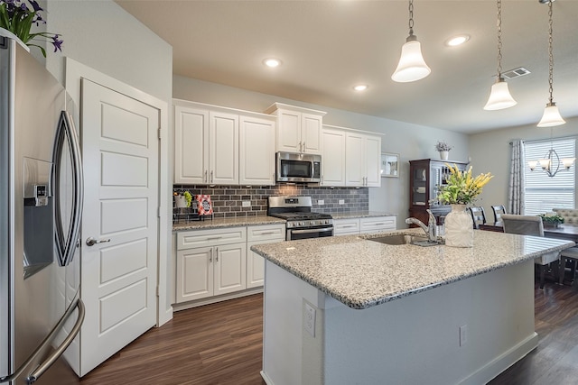 kitchen with visible vents, a sink, tasteful backsplash, stainless steel appliances, and dark wood-style flooring