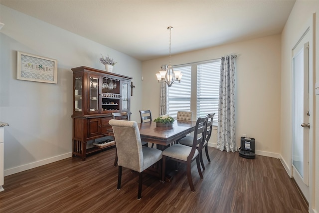 dining space featuring baseboards, a notable chandelier, and dark wood finished floors