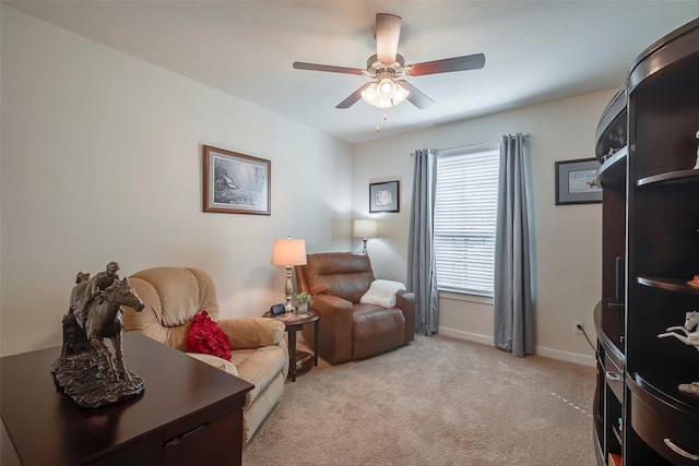 sitting room with light colored carpet, baseboards, and ceiling fan