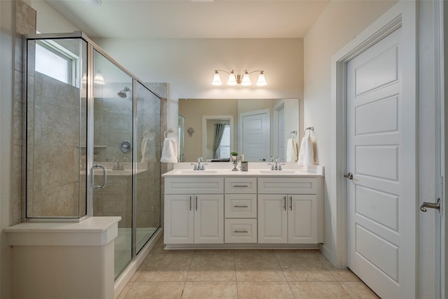 bathroom with double vanity, a stall shower, and a sink