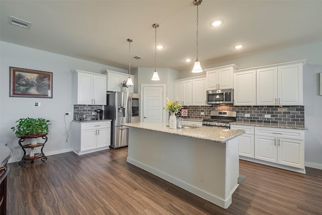 kitchen with appliances with stainless steel finishes, white cabinetry, and dark wood-type flooring