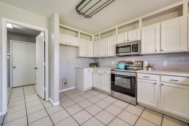 kitchen with light tile patterned floors, stainless steel appliances, decorative backsplash, light countertops, and white cabinetry