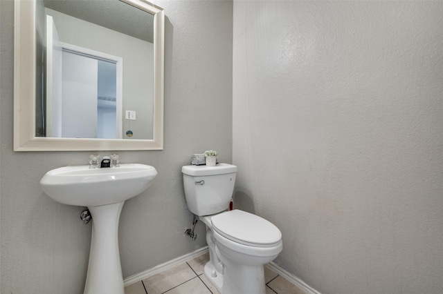 bathroom with tile patterned flooring, toilet, and baseboards