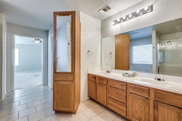 bathroom featuring double vanity, visible vents, a stall shower, and a sink