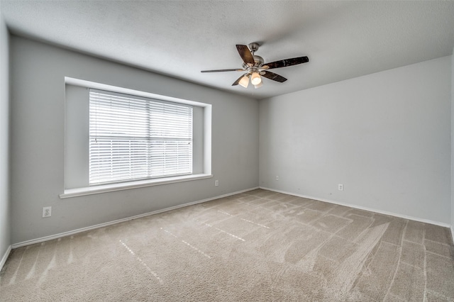 carpeted empty room featuring baseboards, a textured ceiling, and ceiling fan