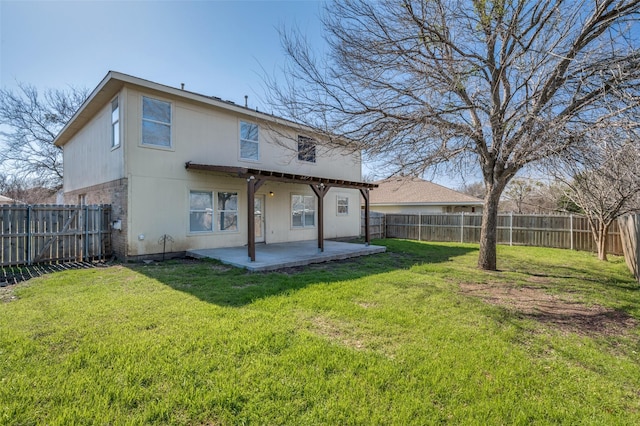 rear view of property featuring a yard, a patio, and a fenced backyard