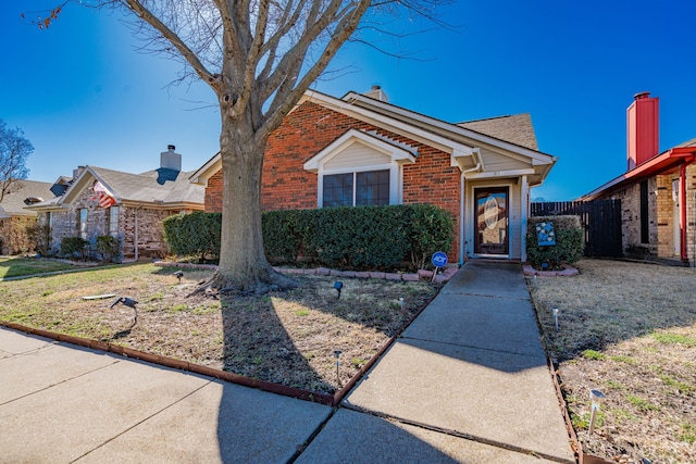 view of front of house featuring brick siding and fence