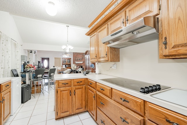 kitchen featuring under cabinet range hood, open floor plan, light countertops, black electric stovetop, and vaulted ceiling