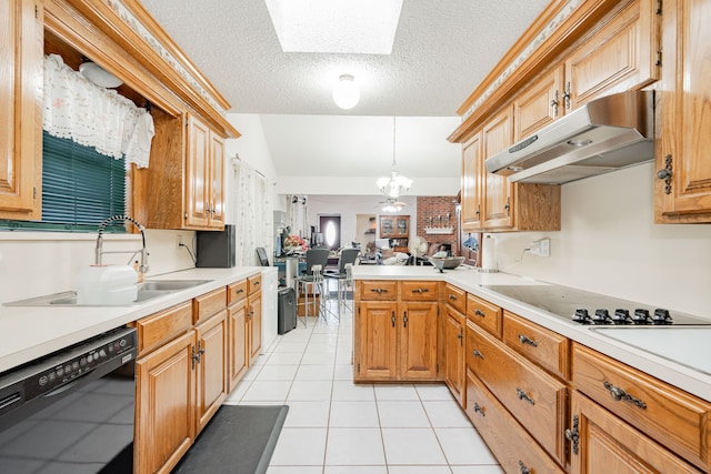 kitchen with under cabinet range hood, black appliances, light countertops, and a sink