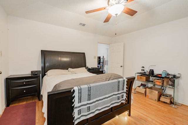 bedroom featuring visible vents, light wood-style floors, and a ceiling fan