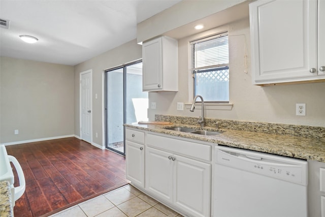 kitchen with visible vents, white dishwasher, a sink, white cabinetry, and light stone countertops