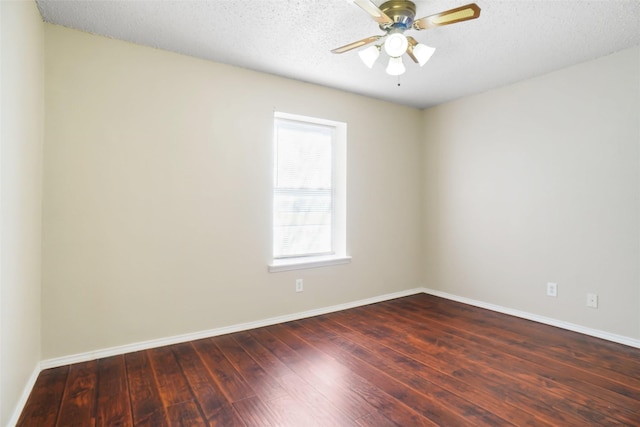 spare room featuring a wealth of natural light, dark wood-style floors, and baseboards