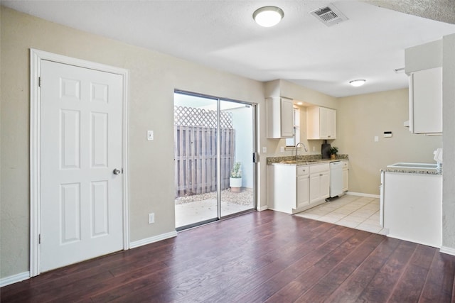 kitchen with white cabinets, light wood-style floors, dishwasher, and visible vents