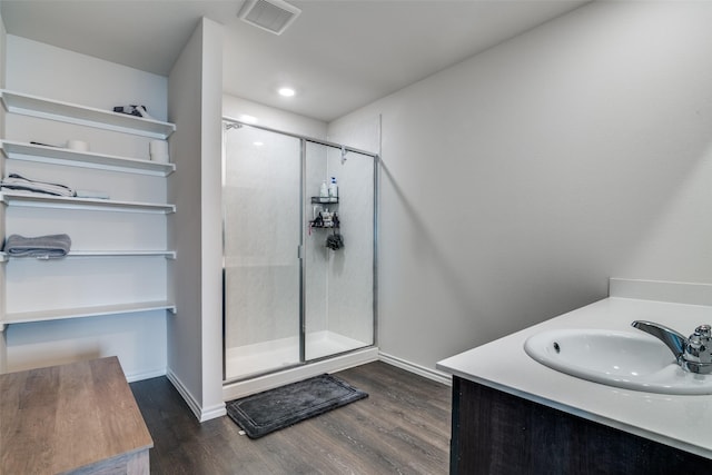 bathroom featuring visible vents, a stall shower, baseboards, and wood finished floors