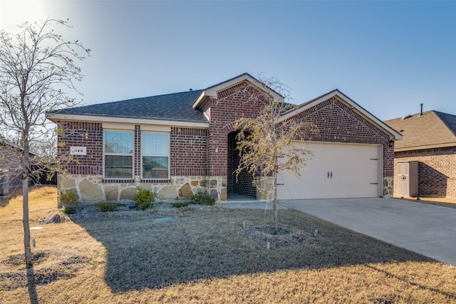 ranch-style house with concrete driveway, a garage, brick siding, and stone siding