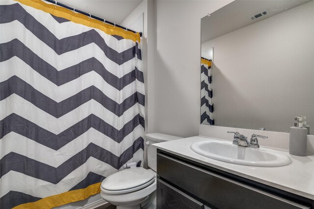 bathroom featuring visible vents, curtained shower, toilet, and vanity