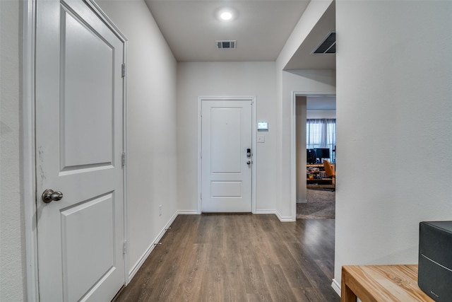 foyer with dark wood-style floors, visible vents, and baseboards