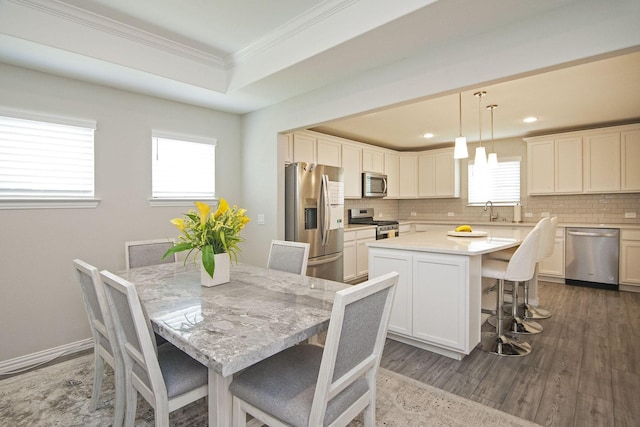 dining area with baseboards, plenty of natural light, dark wood-style floors, and crown molding