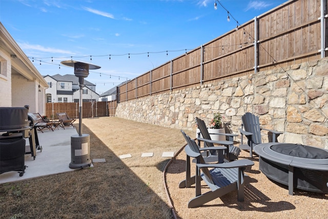 view of yard featuring a patio area, a fire pit, and a fenced backyard