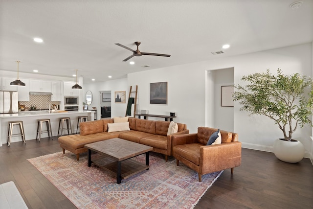 living room with visible vents, recessed lighting, baseboards, ceiling fan, and dark wood-style flooring