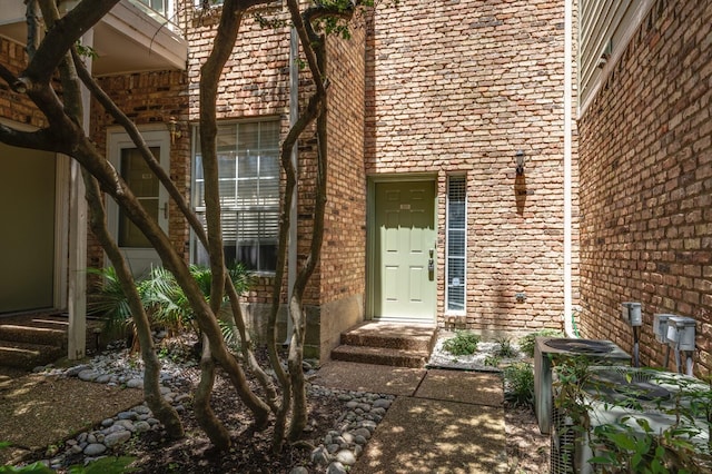 property entrance with central AC unit and brick siding