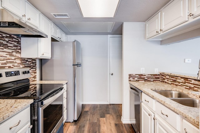 kitchen with visible vents, dark wood-type flooring, white cabinets, under cabinet range hood, and appliances with stainless steel finishes