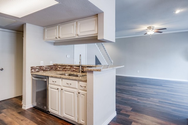 kitchen featuring dishwasher, baseboards, backsplash, and a sink