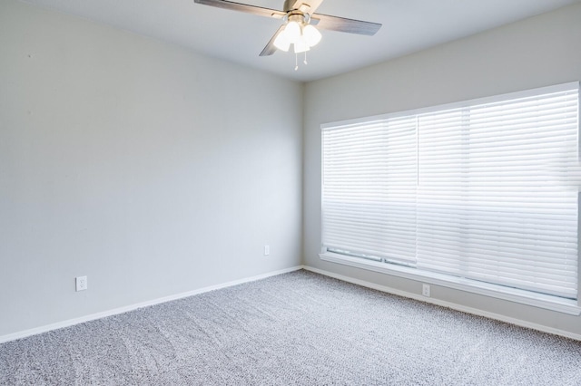 spare room with carpet flooring, baseboards, and ceiling fan