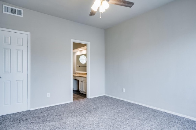 unfurnished bedroom featuring a ceiling fan, baseboards, visible vents, carpet floors, and ensuite bath