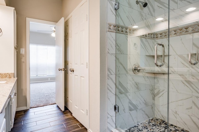 full bathroom with vanity, recessed lighting, a marble finish shower, and wood finish floors