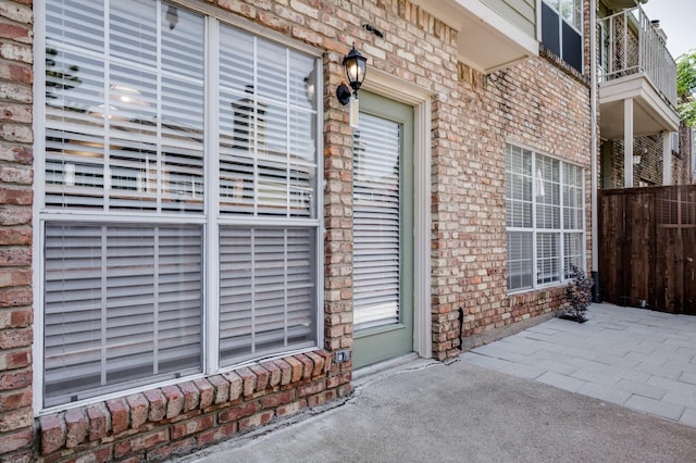 entrance to property with fence and brick siding