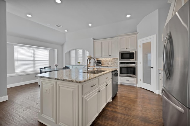 kitchen featuring decorative backsplash, dark wood-type flooring, appliances with stainless steel finishes, and a sink