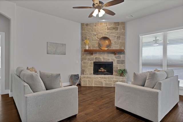 living area with baseboards, visible vents, dark wood finished floors, a fireplace, and ceiling fan