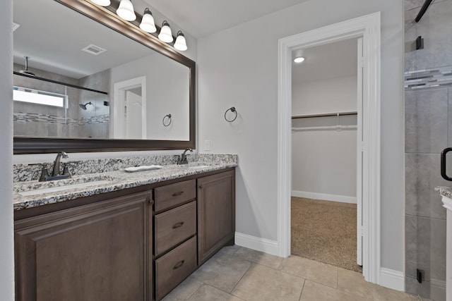 full bath featuring a sink, visible vents, a walk in closet, and a shower stall