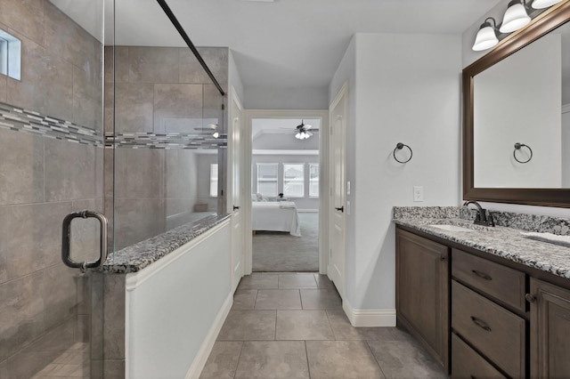 bathroom with a ceiling fan, double vanity, a sink, a shower stall, and connected bathroom