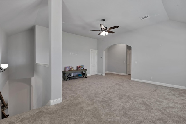 unfurnished living room featuring visible vents, ceiling fan, vaulted ceiling, carpet floors, and arched walkways