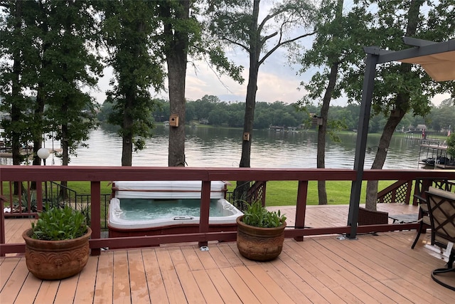 wooden deck featuring hot tub deck surround and a water view